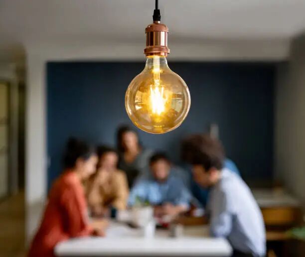 Business idea Creative team discussing a business idea in a meeting - focus on light bulb business stock pictures, royalty-free photos & images