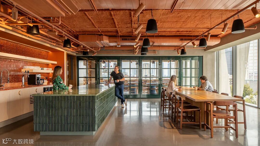 A man and woman walking in a large room with tables and chairs.