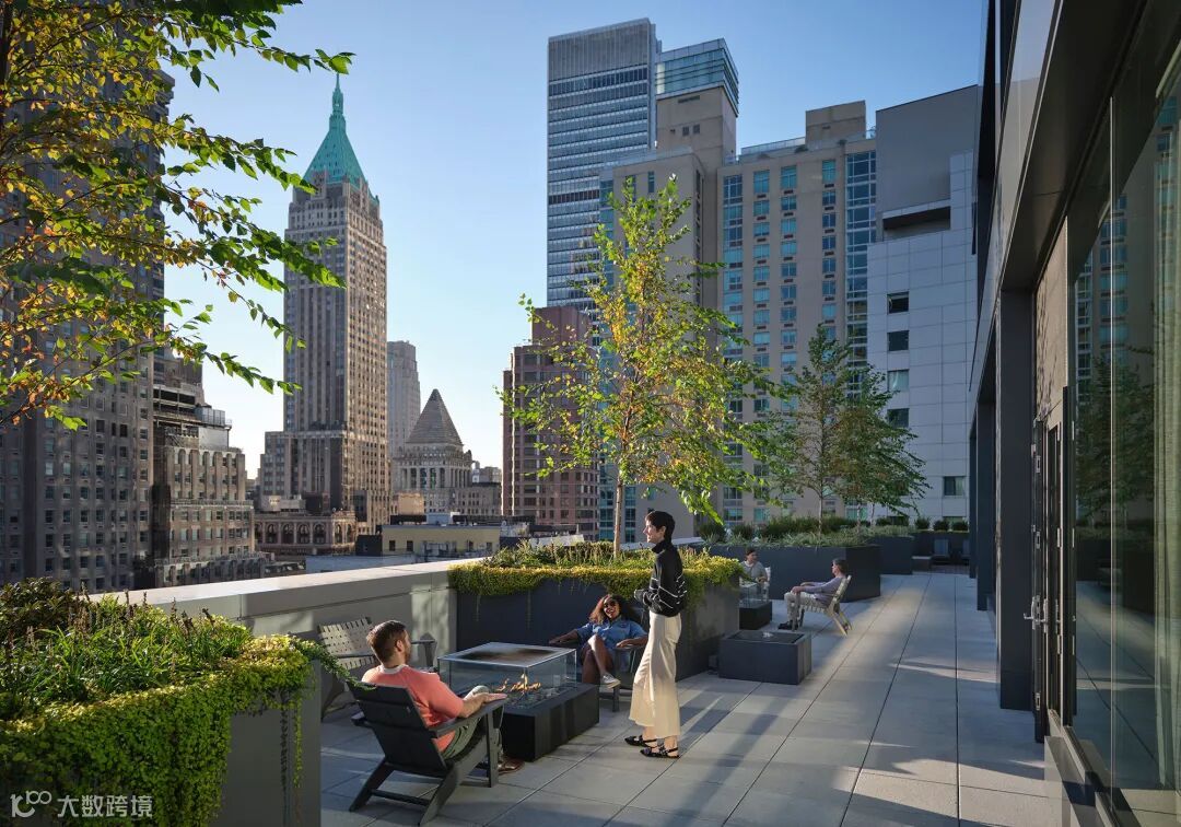 A group of people sitting on a bench in a city.