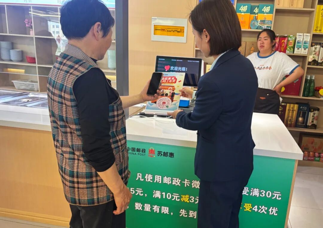 邮政工作人员指导老人用邮政卡享优惠，苏邮惠活动现场便民暖心。 拷贝.jpg
