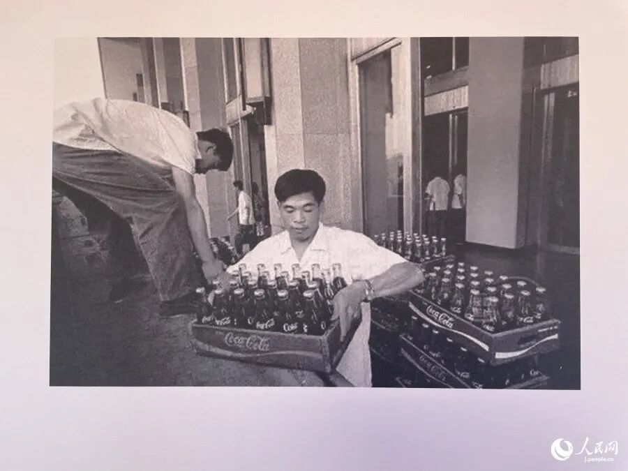 コカ・コーラの搬入作業の様子（「友諠花園」内の説明プレートを撮影・勝又あや子）