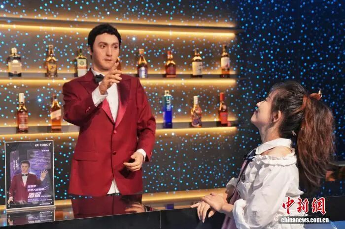 8月8日、北京初のロボットテーマレストラン「ロボット焔究所」が正式に営業を開始。バーテンダーロボットと客の交流の様子。（撮影・張祥毅）