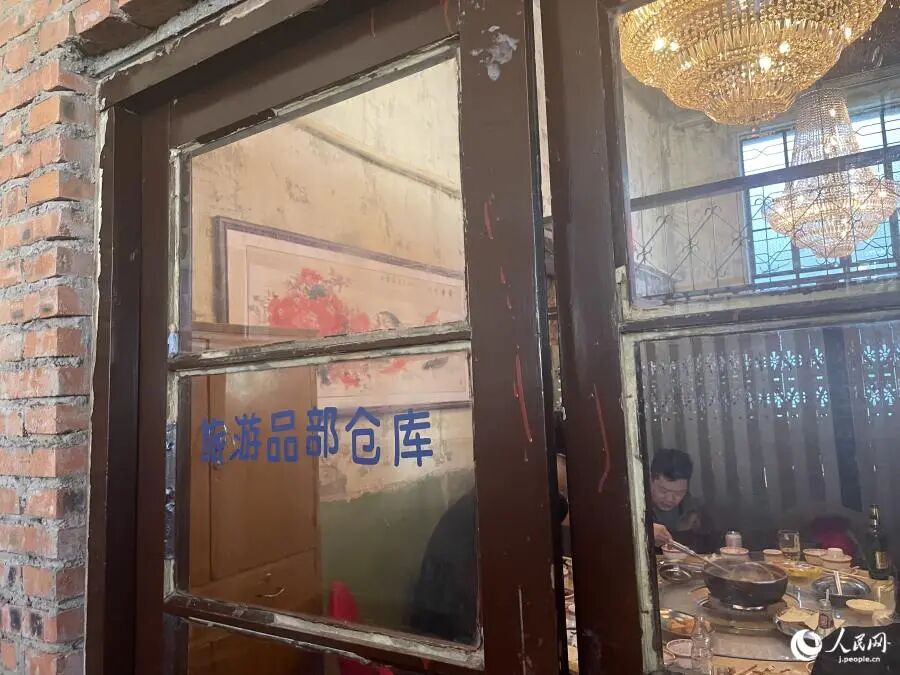 「旅遊品部倉庫」と書かれたガラス扉。「旅遊」は旅行・観光という意味（撮影・勝又あや子）