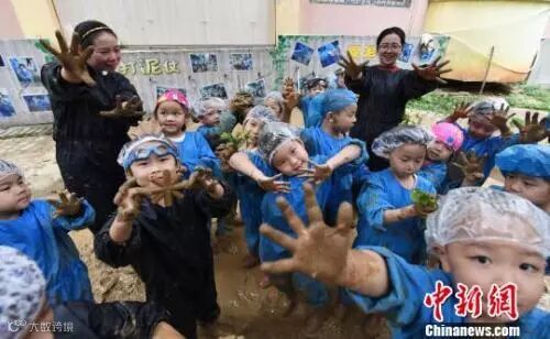 资料图:江西省新余市蓓蕾幼儿园大一班的孩子们在老师带领下抓泥鳅、打泥仗。 赵春亮 摄