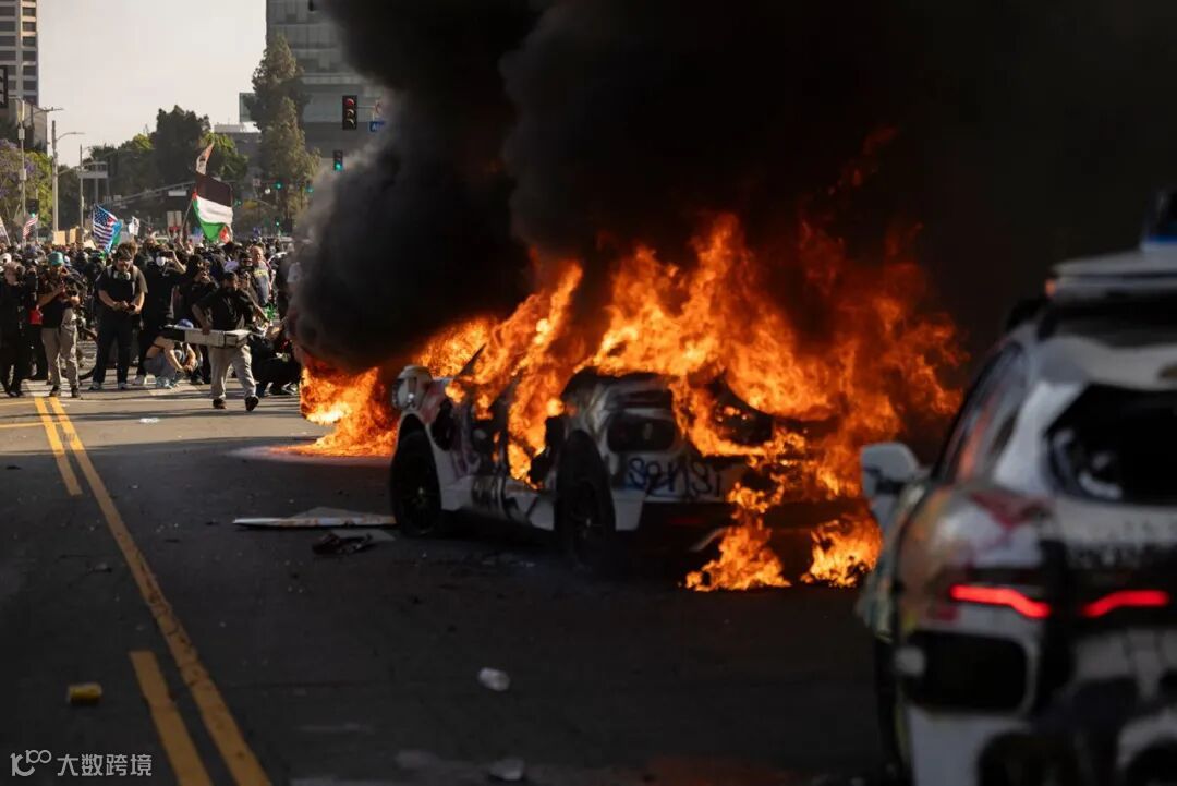 Waymo cars are set on fire as protesters clash with law enforcement near the federal building in Los Angeles, California, on Sunday.