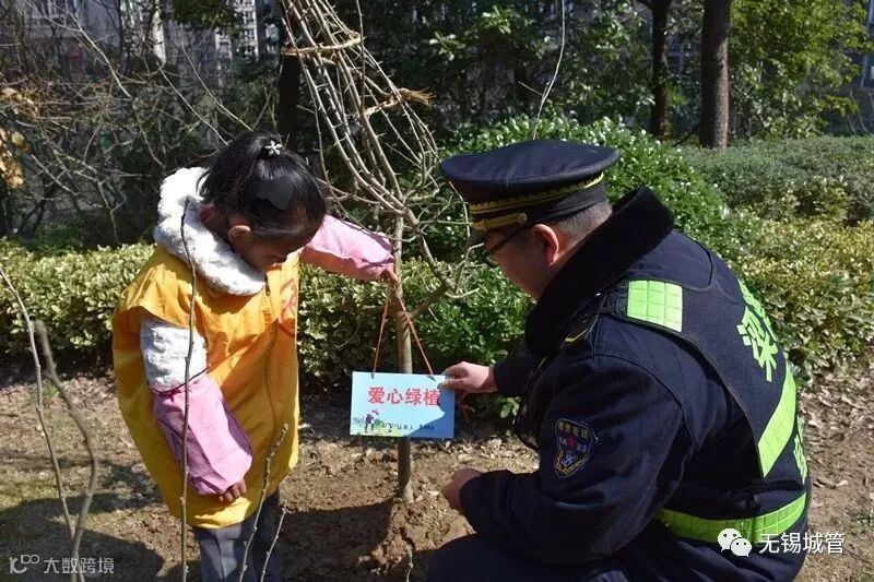 5.城管执法人员与孩子们共植“爱心林”.JPG