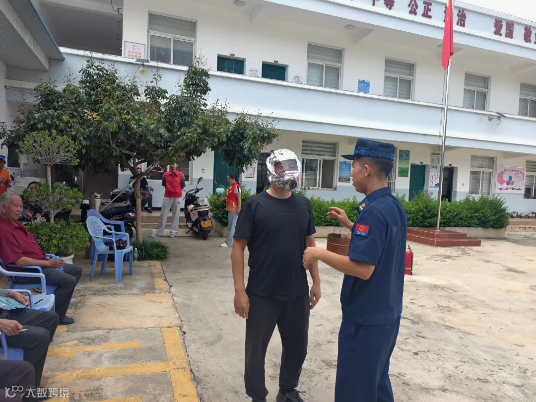 在宣传员的指导下，村民体验佩戴防烟面罩.jpg