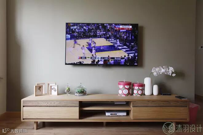 实木色系的电视柜简洁而温馨,柜面上的装饰小摆件无不透露出主人对这个家的用心。