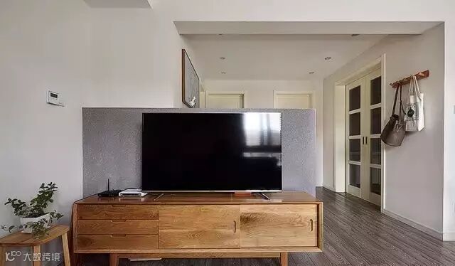 半截高度的电视背景墙设计,弥补了空间布局的不足,也让客厅更通透。