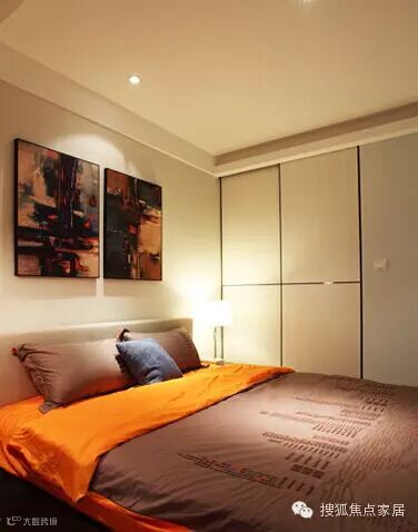 ▲空间改造:进门处打造了迷你步入式衣帽间。深沉色彩的大床,有种温暖的感觉,两幅挂画与枕头相映衬。