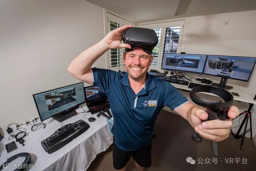 一名男子用右手举起虚拟现实耳机，左手握着控制器，微笑着。