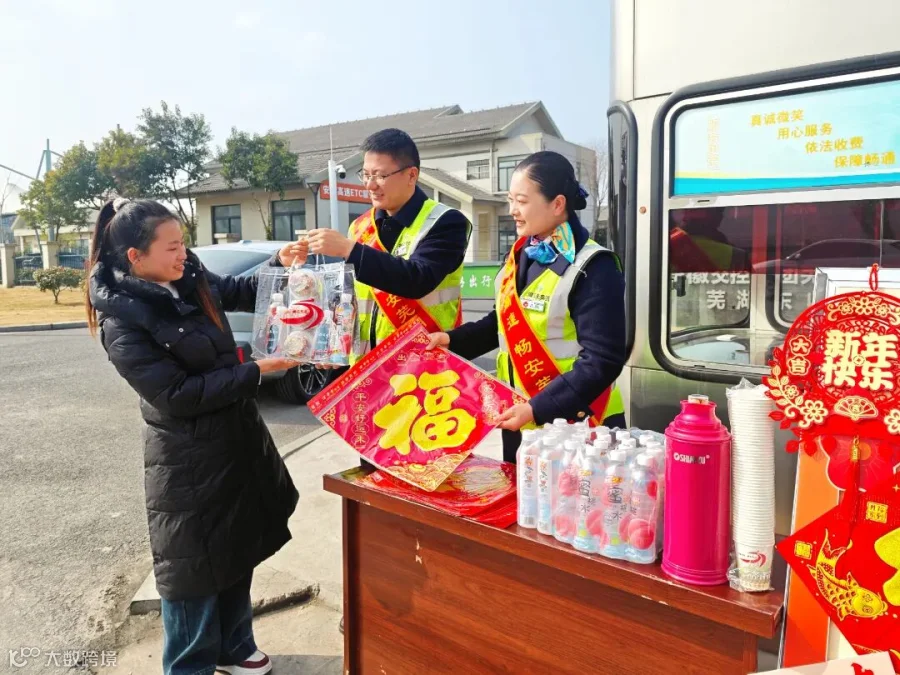 春运期间芜湖中心芜湖东收费站班长毛伟和副班长徐蓉在收费现场开展新春特色便民服务，为司乘人员赠送春节大礼包和节日祝福 (2).jpg