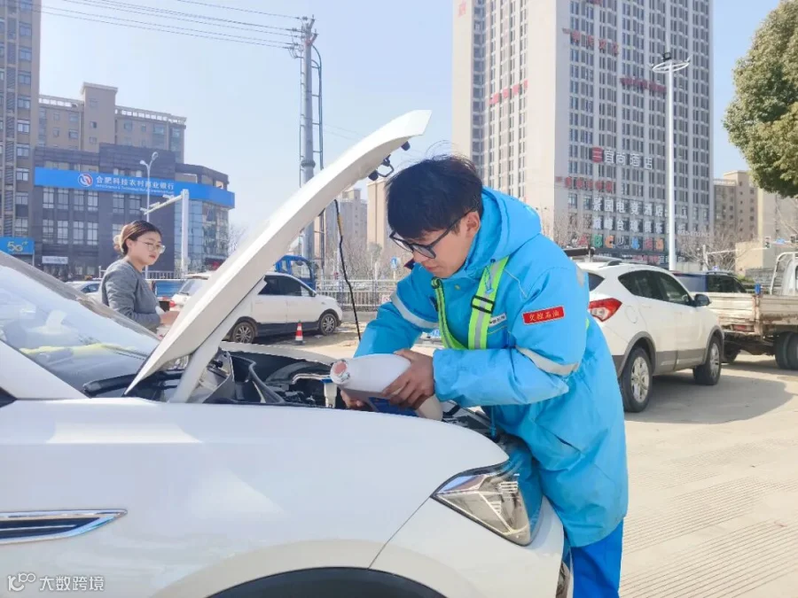 交控石油公司庐江汽车站加油站员工为顾客加注冷却液.jpg