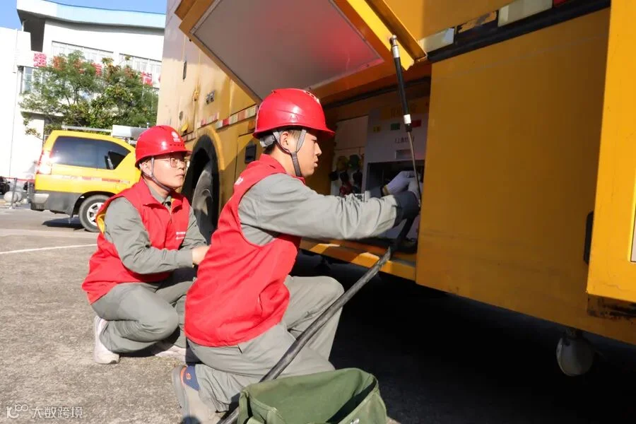 6月3日，国网娄底供电公司员工陈向顺、曾振锋在娄底一中附属实验学校对高考保电车开展接线准备工作。.jpg
