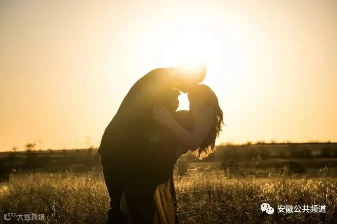 一个男人在一个金色的钟声中在一个田地里亲吻一个女人