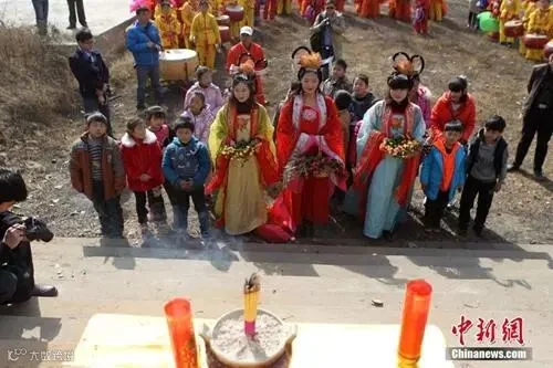 资料图:民众在“春姑娘”的带领下祭拜灶神。当日是农历腊月二十三,中国传统“小年”。 中新社发 王中举 摄