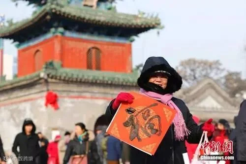 资料图:农历腊月廿三小年儿来临,北京东岳庙举办迎新春送春联活动,参与者甚众。中新社记者 富田 摄_副本