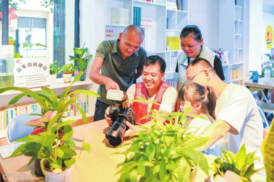 在桂林大社区综合服务中心的货车司机驿站内，志愿者向货车司机和居民展示刚刚拍摄的照片。本报记者 苏弼坤 摄.jpg