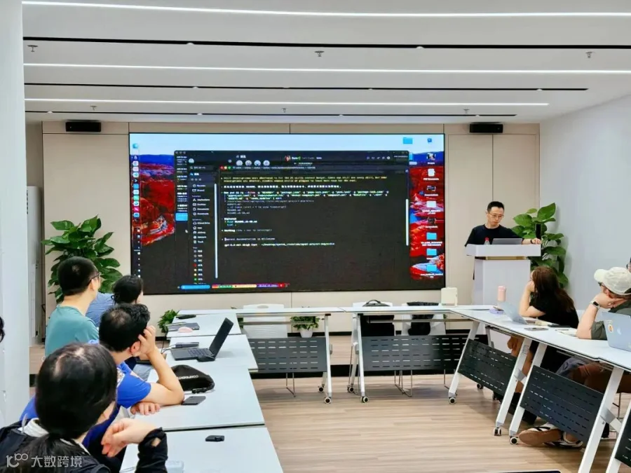讲台上的演示正在推进，屏幕里密密麻麻的代码，也让这场交流更显“硬核”。