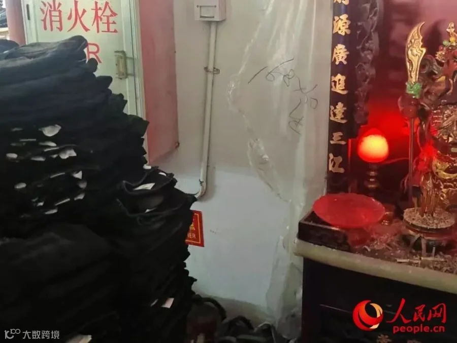 消火栓被牛仔裤挡住，旁边还有在燃烧的香火。人民网记者 王子锋摄